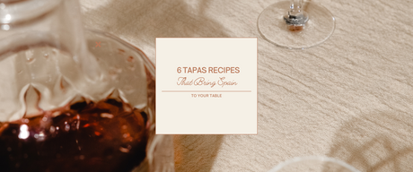 Close-up of a table setting with wine and a card featuring authentic Spanish tapas recipes