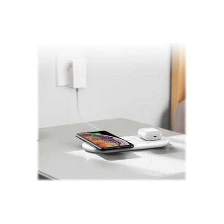 Anker dual wireless charger pad charging smartphone and wireless earbuds on white surface