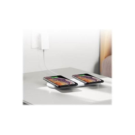Anker dual wireless charger pad charging two smartphones side by side on a white table