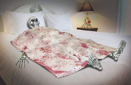Bloody skeleton Halloween party decorations on a bed with a skull head and bones