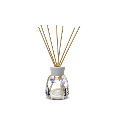 Yankee Candle reed diffuser with floral design and natural wooden reeds in clear glass bottle