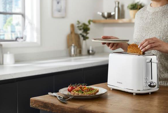 Toaster in a tidy kitchen with plates and food on the table