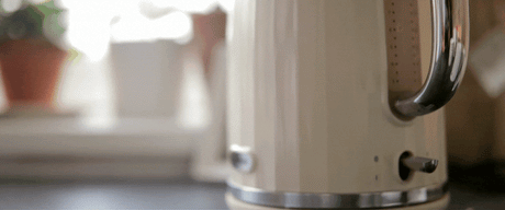 Close-up of a kettle getting turned on to boil in a kitchen setting