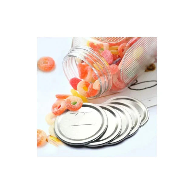Ball mason jar lids stacked next to a glass jar filled with colorful ring-shaped candies