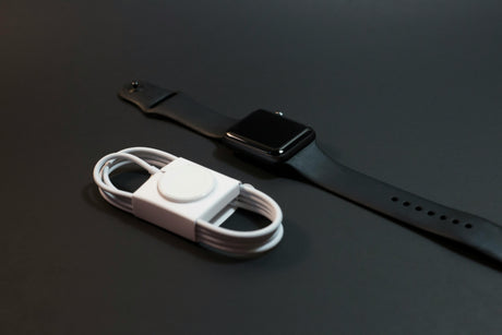 Affordable tech chargers including a wireless charger cable and a black smartwatch on a dark surface