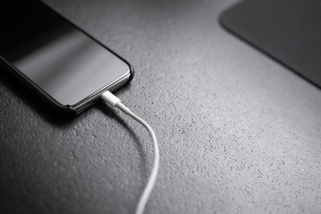 Modern smartphone charging with a cable representing wireless phone chargers collection and efficient tech