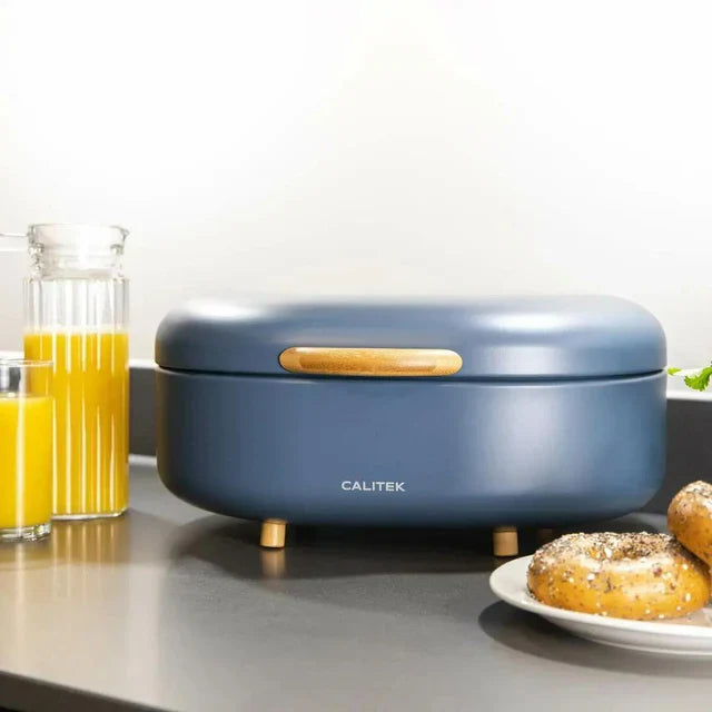 Calitek kitchen appliance in blue on countertop with juice and bagels, modern compact cooking device