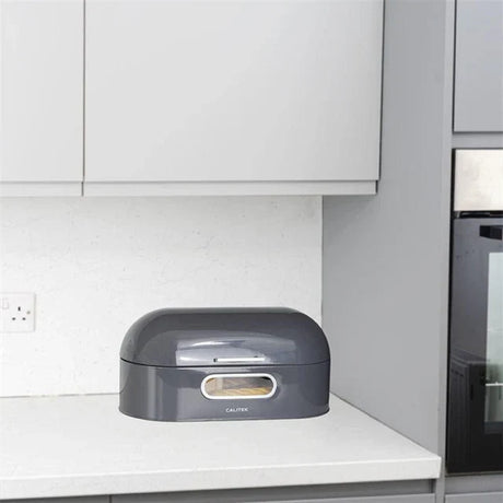 Sleek gray modern bread bins for kitchen placed on a white kitchen countertop under cabinets