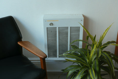 Modern oil filled radiators for home providing efficient heating next to a black chair and green plant