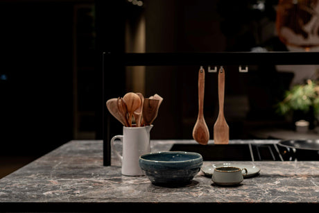 Best cooking equipment for home including wooden utensils and ceramic bowls displayed on kitchen countertop