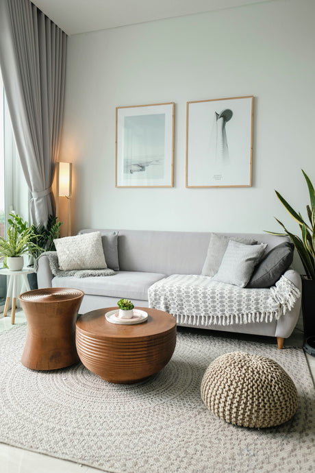 Modern living room featuring decorative throw pillows on a gray sofa with cozy blankets and wooden tables