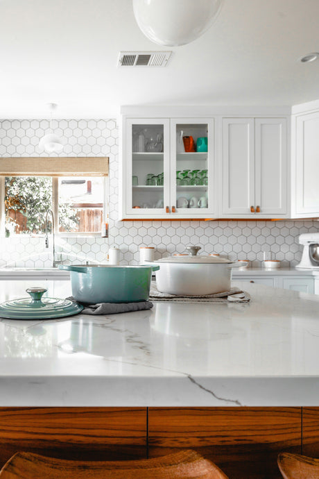 Modern kitchen featuring latest homeware arrivals including pots on marble countertop and white cabinetry