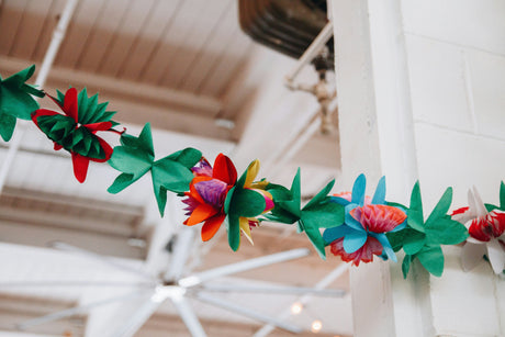 Colorful birthday party decorations featuring vibrant floral garland hanging indoors