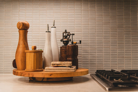 Premium kitchen equipment including wooden and ceramic utensils displayed on a rotating wooden tray near a stove