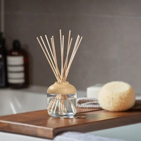 New homeware arrivals featuring reed diffuser and bath accessories on wooden tray in bathroom setting