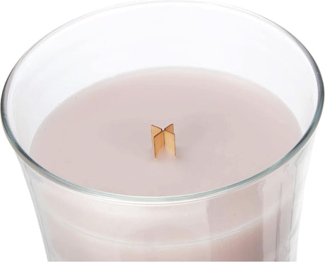Large rosewood scented candle large in clear glass container with wooden wick burning softly