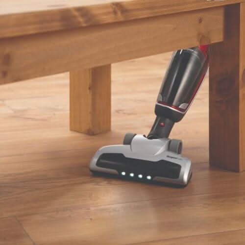 Morphy Richards 2-in-1 vacuum cleaner reaching under a wooden table for effective cleaning