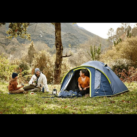 3 person dome tent set up in a scenic outdoor location with campers enjoying a relaxing afternoon
