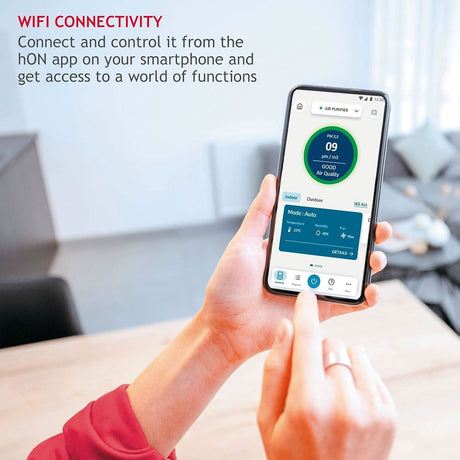 Person controlling Hoover 300 air purifier with smartphone app showing air quality and mode settings