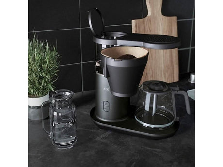 AEG coffee machine 1600W black drip coffee maker with glass carafe and open lid on kitchen counter