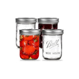 Set of Ball mason jars with silver wide mouth canning lids, one jar filled with preserved red peppers