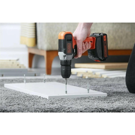Black and Decker 18V drill driver used to fasten screws into white wood on a carpeted floor