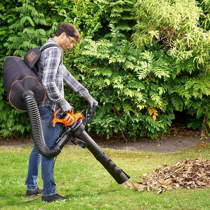 Man using Black & Decker 3-in-1 blower vacuum to clear dry leaves in garden with backpack design