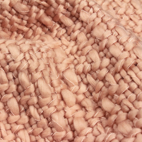 Close-up of soft woven blush pink throw blanket showing thick textured yarn fibers