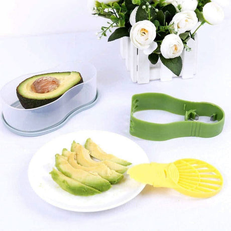 Calitek avocado slicer and masher set with green and yellow tools slicing avocado on white plate