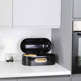 Calitek black retro style bread bin with open lid showing bread inside on kitchen countertop