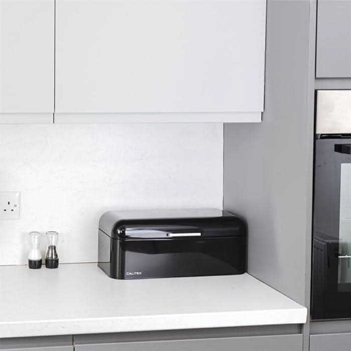 Calitek black retro style bread bin on white kitchen countertop with salt and pepper shakers