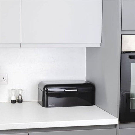 Calitek black retro style bread bin on white kitchen countertop with salt and pepper shakers
