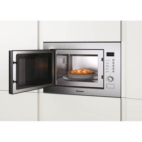 Candy 25L built-in microwave with stainless steel finish and open door showing a baked pie inside