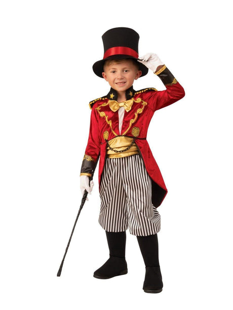 Boy wearing a child circus ringmaster costume with red coat, striped pants, top hat, and holding a whip