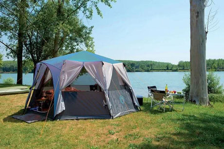 CLICKK Home Store 8 person family camping tent set up by a lake with outdoor chairs and table