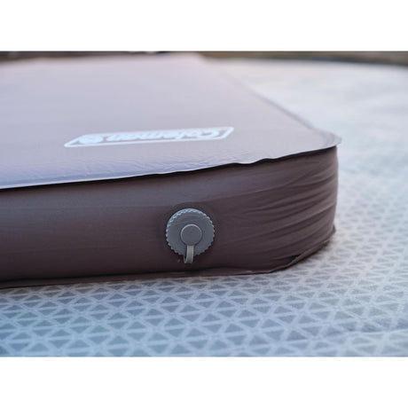Close-up of CLICKK Home Store brown self inflating sleeping mat valve on geometric patterned surface