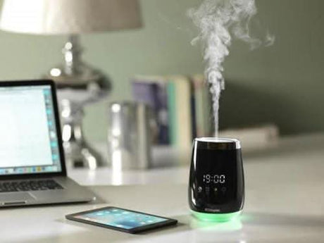 Dimplex aroma diffuser black digital model emitting mist on a white desk next to laptop and tablet