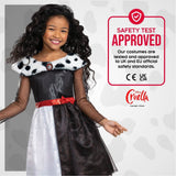 Smiling girl wearing Disney Villain Cruella costume with black and white dress and red belt
