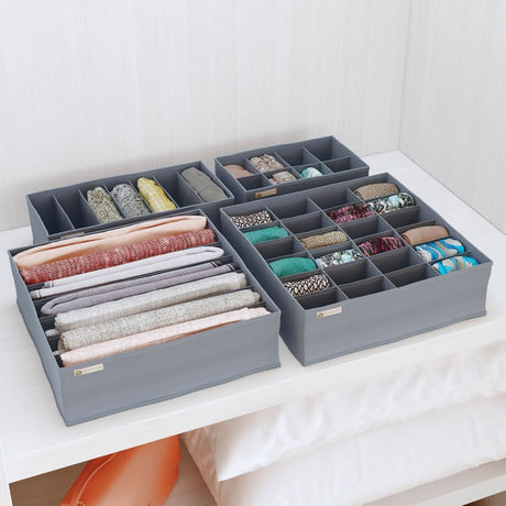 Foldable drawer organizer set in gray neatly storing clothes and accessories on a white shelf