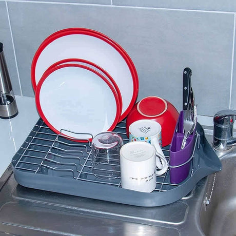 Calitek dish drying rack with drip tray holding plates cups and knives on kitchen sink
