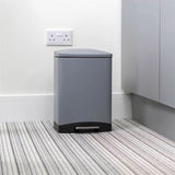 Calitek 6L pedal bin with soft close lid in gray with black base on striped carpet