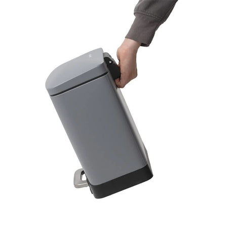Calitek 6L pedal bin with soft close lid in gray held by hand for easy carrying