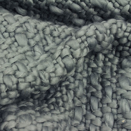Close-up of soft textured grey acrylic throw blanket with chunky knit weave pattern
