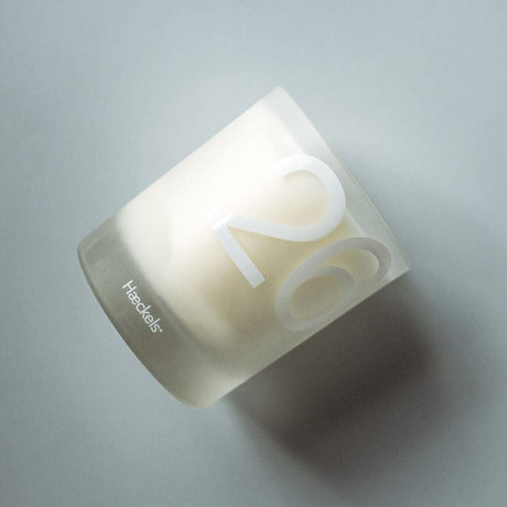 Haeckels botany candle in a frosted glass container with a minimalist design