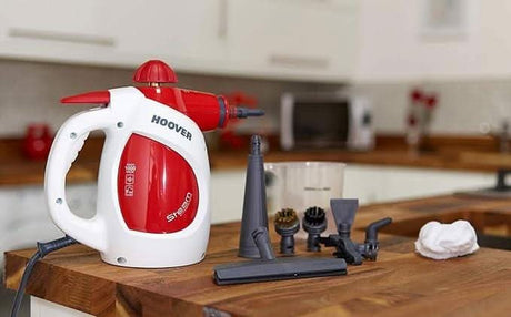 Hoover handheld steam cleaner chemical-free with multiple cleaning attachments on wooden kitchen counter