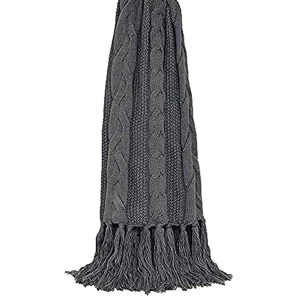Light grey throw blanket with cable knit pattern and long fringe tassels hanging vertically
