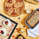 Baked apple tart, bread loaf, muffins, and berry desserts on de Buyer baking mats showcasing premium baking accessories set by Magimix x De Buyer