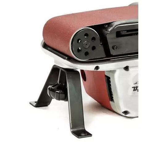 Close-up of Makita M9400 belt sander showing sanding belt and black metal stand