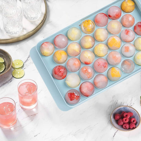 CLICKK Home Store mini sphere ice cube tray with colorful fruit-filled ice spheres on white marble countertop