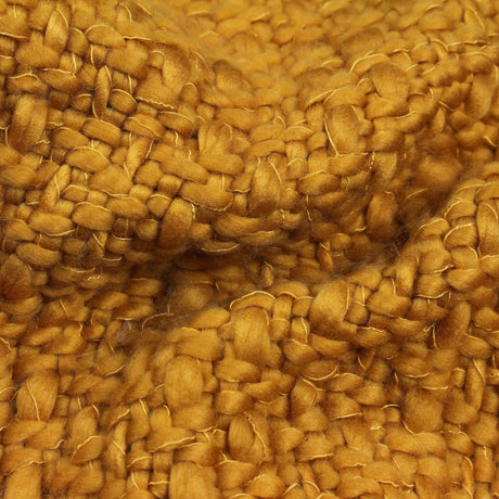 Close-up of chunky knit texture in mustard acrylic throw blanket showing soft woven fibers